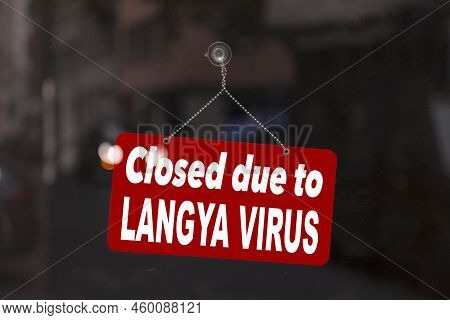 Close-up On A Red Sign In The Window Of A Shop Displaying The Message In English - Closed Due To Lan