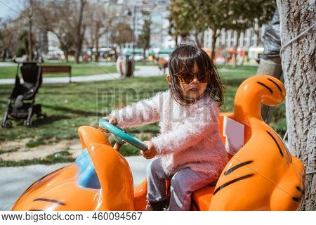 Little Girl On Kiddie Ride Outdoor Having Fun