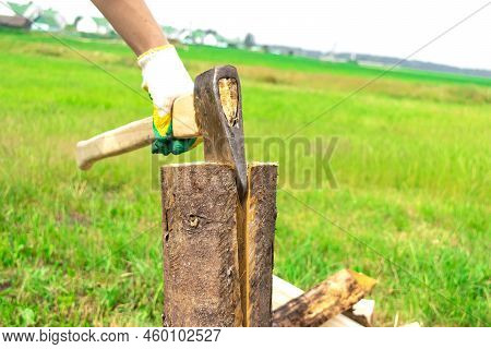 The Wood Chopper Sticks Out In Wooden Hemp. Ax And Ax Handle. Man's , Male Hands In White Colors Glo
