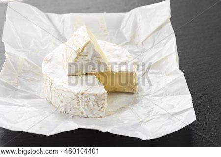 Brie Type Of Cheese. Close Up On Camember Cheese. Pieces Of Soft Cheese Reveal Its Runny Cream Textu