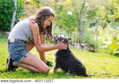 Girl In Affectionate Attitude With A Dog. Complicit Look Between Girl And Dog. Concept Of Love For A