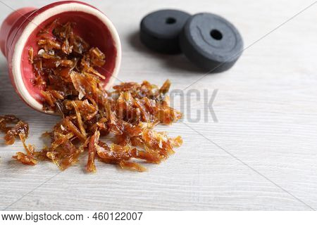 Red Clay Bowl Of Hookah With Aromatic Tobacco And Charcoals On Wooden Table, Closeup. Space For Text