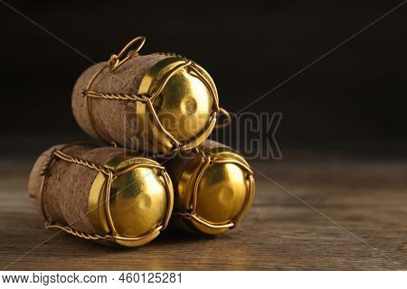 Corks Of Sparkling Wine And Muselet Caps On Wooden Table, Closeup. Space For Text