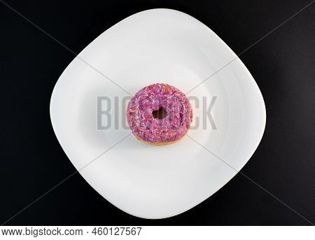 Pink Doughnut With Powder On A White Plate And Dark Background