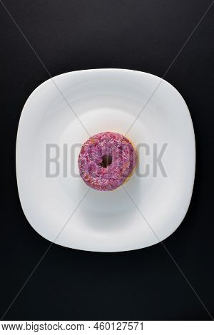 Pink Doughnut With Powder On A White Plate And Dark Background