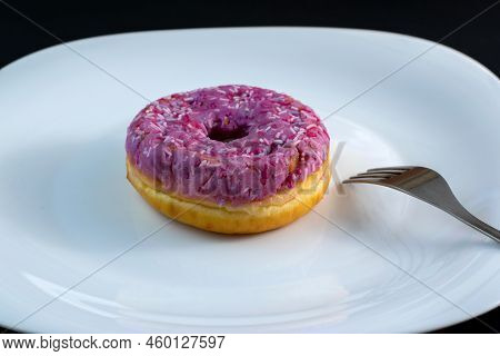 Pink Doughnut With Powder On A White Plate With A Fork