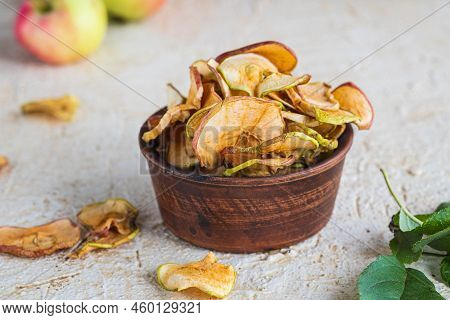 Dried Sliced Apples In A Brown Bowl On A Light Concrete Background. Natural Fruit Chips. Healthy Foo
