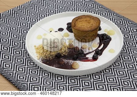 Warm Rye Cake With Orange, Molasses, Coconut. Served With Chokeberry Sauce, Homemade Ice Cream And A