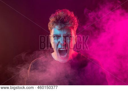 Shouting Excited Young Man With Bright Emotions Isolated Over Pink Background With Smoke. Concept Of