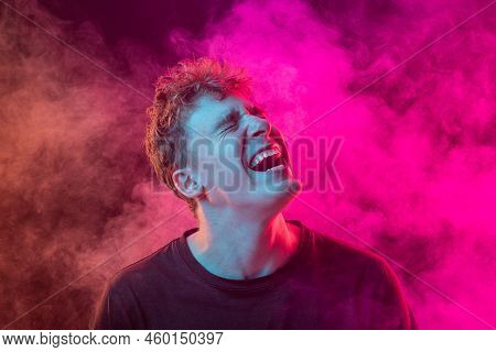 Despair. Shouting Excited Young Man With Bright Emotions Isolated Over Pink Background With Smoke. C