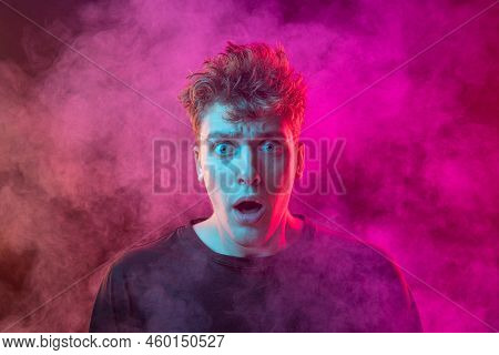Shouting Excited Young Man With Bright Emotions Isolated Over Pink Background With Smoke. Concept Of