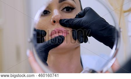 Clinic, Cosmetology Room, In The Reflection Of Mirror, The Doctor Probes The Area Of Lips For Hyalur