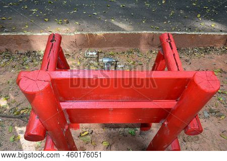 Chair In Red Color With Pedal For Exercises. Equipment For Use By The Elderly In Municipal Forest. B