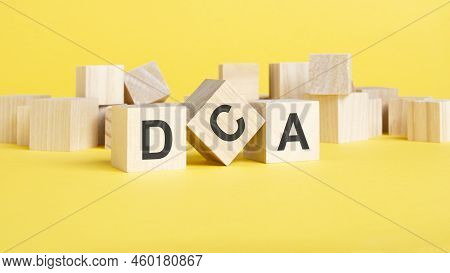 Wooden Blocks With Text Dca On Yellow Background. Dollar Cost Averaging Concept