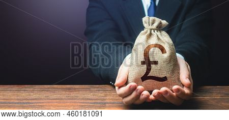 Businessman Holds Out British Pound Sterling Money Bag. Getting A Grant. Mortgage, Loan Approval. Sa