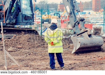 Excavator And Workers At A Construction Site
