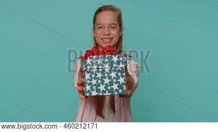 Positive Smiling Lovely Pretty Teenager Girl Presenting Birthday Gift Box Stretches Out Hands, Offer