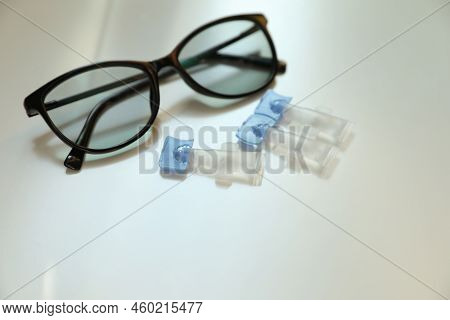 Single Dose Eye Drops And Glasses On White Table