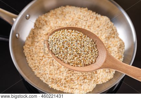 Toasted Sesame Seeds In A Wooden Spoon Over Stainless Steel Skillet. Roasting Organic Benne Grains I