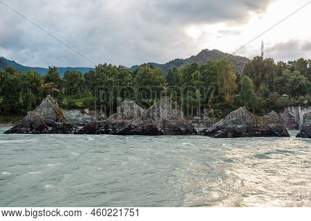 A Fast-flowing Wide And Full-flowing Mountain River. Large Rocks Stick Out Of The Water. Big Mountai