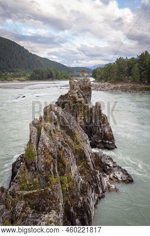 A Fast-flowing Wide And Full-flowing Mountain River. Large Rocks Stick Out Of The Water. Big Mountai
