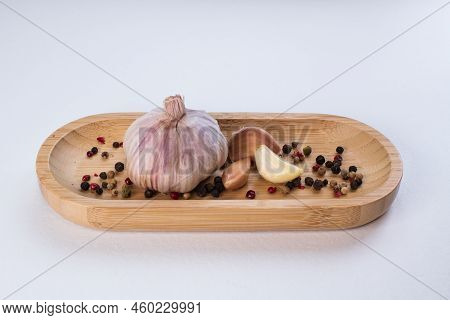 Garlic In A Wooden Bowl On A White Background