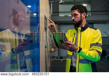 Young Industrial Worker Operating Cnc Machine At Metal Machining Industry