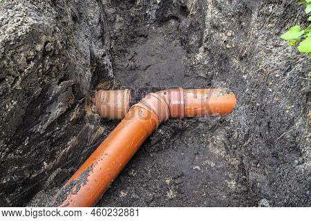 An Orange Plastic Pipe From A Septic Tank With A Diameter Of 160 Mm Lying In A Ditch.