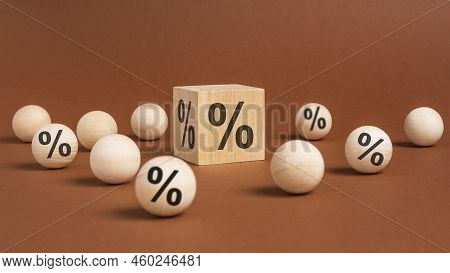One Wooden Cube With Percent Symbol Printed And Many Wooden Balls, Viewed In Close-up With Shadow On