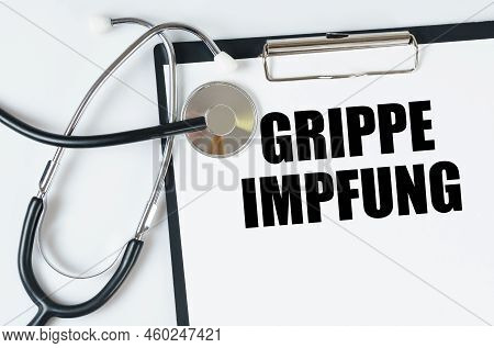 Medical Concept. On A White Surface, A Stethoscope And A Tablet With An Inscription - Grippe Impfung
