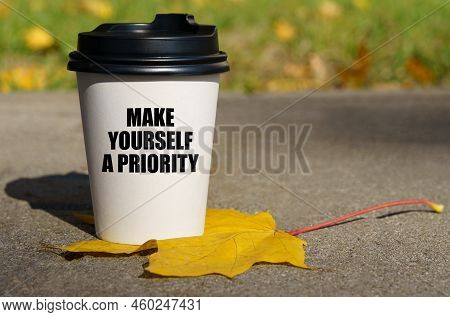 On A Yellow Maple Leaf There Is A Cup Of Coffee On Which Is Written - Make Yourself A Priority. Busi