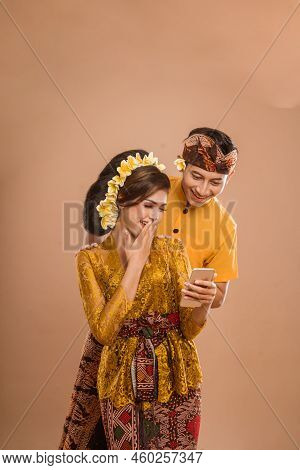 Suprised Balinese Couple While Looking At Her Mobil Phone Screen