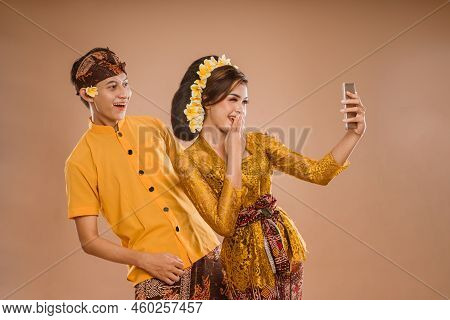 Suprised Balinese Couple While Looking At Her Mobil Phone Screen