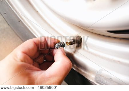 The Car Driver Manually Remove The Tire Valve Cap For Reinflating The Tire.