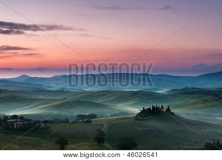 Weiße Nebel und lila Wolken an einem schönen Morgen in den toskanischen Hügeln in der Nähe von Pienza