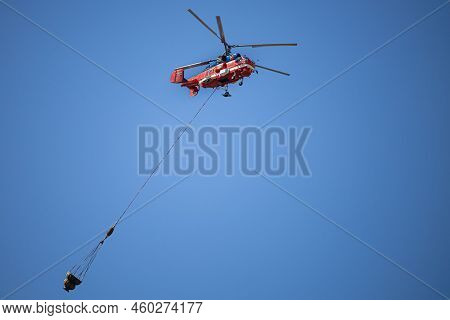 Moscow, Russia - July 21, 2022: Helicopter Carries Cargo In A Hanging Basket. High Quality Photo