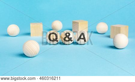 Concept Text 'q And A' On Wooden Spheras On A Beautiful Blue Background. Business Concept. Copy Spac