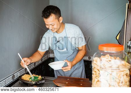 The Seller Cooks Fried Chicken Noodles On A Hot Plate