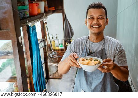 Man Seller Smiling While Bringing A Bowl Of Chicken Noodles