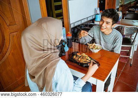 Young Male Customer Enjoying Chicken Noodles With His Girlfriend