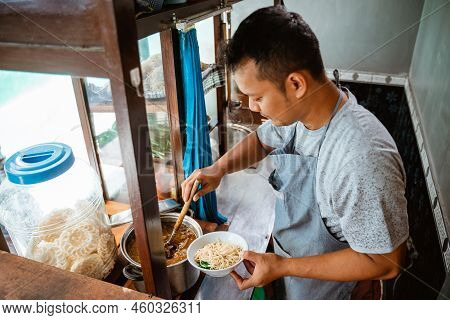 Man Seller Put The Chicken Seasoning Topping On The Noodles