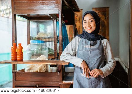 Relaxed Hijab Woman Wearing Apron Smiling While Standing