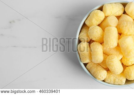Bowl Of Delicious Crispy Corn Sticks On White Marble Table, Top View. Space For Text