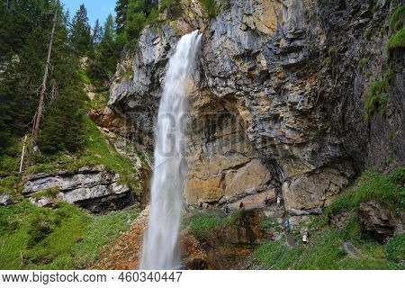 Obertauern, Austria - August 5, 2022: People Walk The Trail Beneath Johannes Waterfall In Tauern Mou