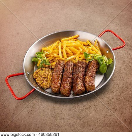 Grilled Romanian Meat Rolls Called Mititei Or Mici Served With Fries And Dijon Mustard. Traditional 