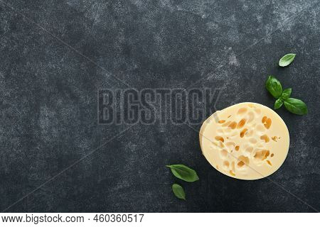 Cheese Maasdam Or Radamer. Piece Of Cheese On Black Marble Or Stone Standa On Black Concrete Backgro