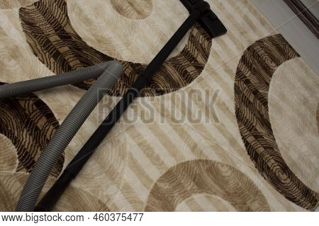 Top View Of The Vacuum Parts Threw On The Brown Carpet. Floor Nozzle, Plastic Tube And Hose Assembly