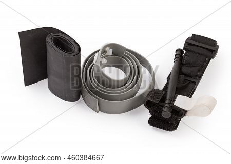 Modern Military Tourniquet And Simple Outdated Hemostatic Bandages In The Form Of Soft Wide Rubber R