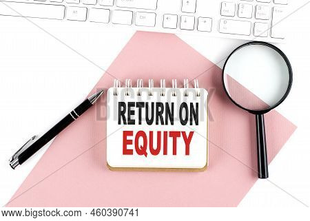 Business Concept. Notebook With Text Return On Equity On Pink Paper With Magnifier, Keyboard And Pen