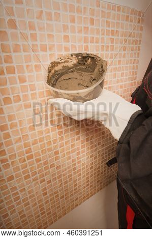 Older Man Working In Empty Apartment Repairing Holes In Walls
